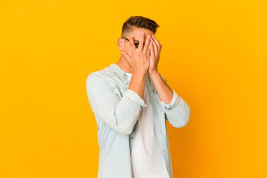 Genç, yakışıklı, beyaz tenli, izole bir adam parmaklarıyla gözünü kırp korkmuş ve gergin..