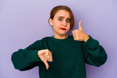 Genç Arap melez kadın baş parmağını kaldırıyor ve baş parmağını eğiyor, zor seçim konsepti