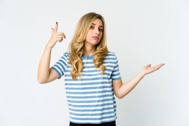 Genç, beyaz, sarışın bir kadın elinde bir ürün tutuyor..