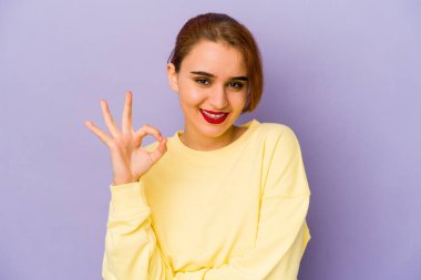 Genç Arap melez kadın göz kırpıyor ve elleriyle iyi bir jest yapıyor..