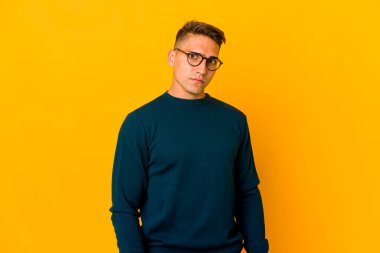 Yakışıklı, beyaz bir adam hoşnutsuzca kaşlarını çatmış, kollarını kavuşturmuş..