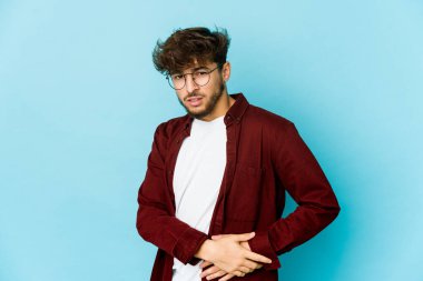 Mavi arka planda genç bir Arap adamın karaciğeri ağrıyor, karnı ağrıyor..