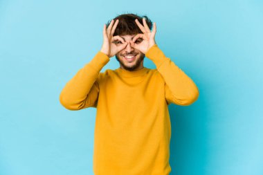 Mavi arka plandaki genç Arap gözlerinde sorun olmadığını gösteriyor.