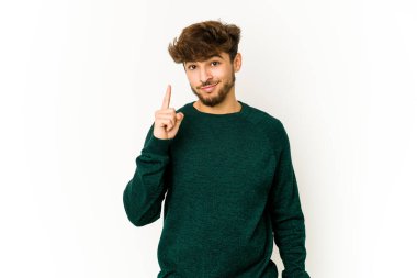 Beyaz arka planda genç bir Arap bir numarayı parmağıyla gösteriyor..