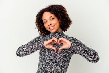Genç Afro-Amerikan melez kadın kendini izole edip gülümsedi ve elleriyle kalp şeklini gösterdi..