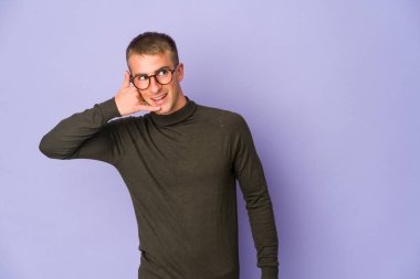 Genç, beyaz, yakışıklı bir adam cep telefonu hareketini parmaklarıyla gösteriyor..