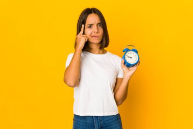 Elinde bir megafon tutan genç İspanyol kadın parmağıyla tapınağı işaret ediyor, düşünüyor ve bir göreve odaklanıyor..