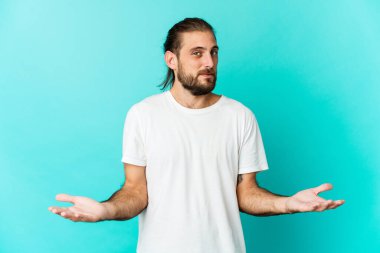 Uzun saçlı genç adam hoş bir yüz ifadesi sergiliyor..