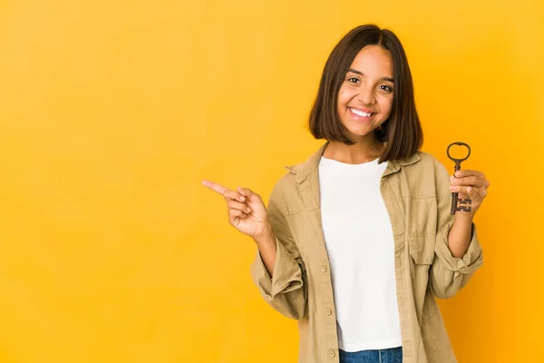 Young Hispanic Woman Holding Old Key Smiling Pointing Aside Showing — 图库照片