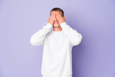 Beyaz tenli yakışıklı adam elleriyle gözlerini kapatıyor. Gülümsüyor ve bir sürpriz bekliyor..