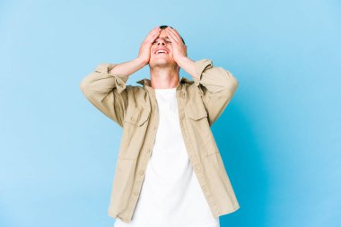 Kafkasyalı yakışıklı genç adam ellerini başının üstünde tutarak neşeyle gülüyor. Mutluluk kavramı.