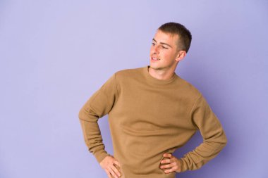 Beyaz tenli yakışıklı, kendine güveni tam. Ellerini kalçasından ayırmıyor..