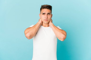 Beyaz tenli yakışıklı bir adam izole edilmiş kafasının arkasına dokunuyor, düşünüyor ve bir seçim yapıyor..