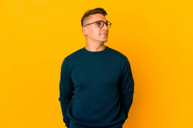 Genç, yakışıklı, beyaz bir adam izole edilmiş, rahat ve mutlu bir şekilde gülüyor, boynunda dişlerini gösteriyor..