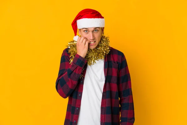 Junger Kaukasischer Mann Mit Weihnachtsmütze Und Geschenk Auf Gelbem Hintergrund — Stockfoto