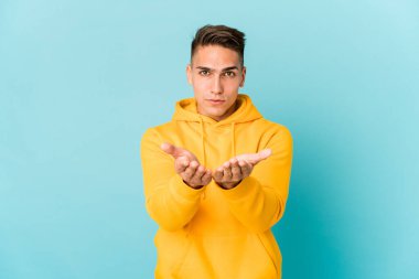 Beyaz tenli yakışıklı adam, dudaklarını katlayıp avuç içlerine hava öpücüğü yolluyor..