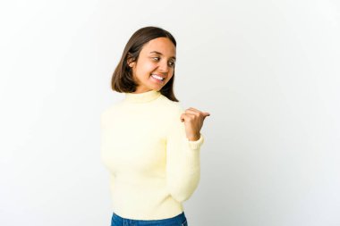 Genç melez kadın başparmağıyla işaret ediyor, gülüyor ve kaygısız.