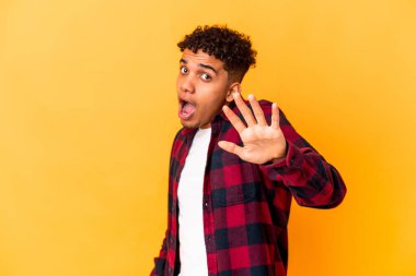 Genç Afro-Amerikalı kıvırcık adam yakın bir tehlikeden dolayı şoka uğruyor.