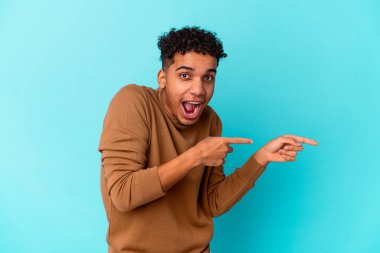 Genç Afro-Amerikalı kıvırcık adam mavi üzerine izole edilmiş..