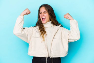 Genç beyaz kıvırcık saçlı kadın zafer kazandıktan sonra yumruğunu kaldırdı..