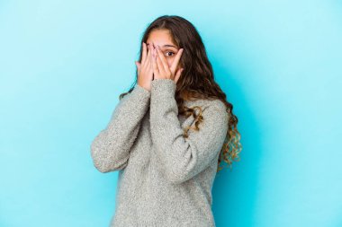 Genç, beyaz, kıvırcık saçlı kadın parmaklarıyla gözünü kırp korkmuş ve gergin..