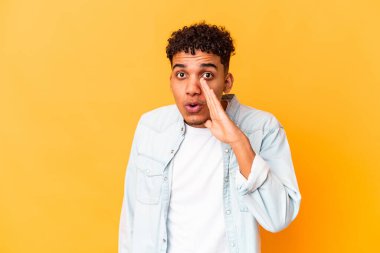 Genç Afro-Amerikalı kıvırcık adam mor üzerine izole edilmiş gizli bir sıcak fren haberi veriyor ve yan bakıyor.