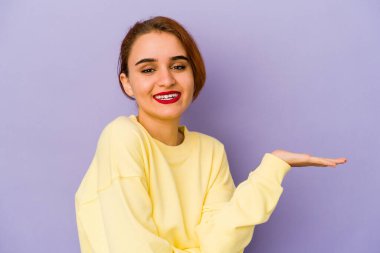 Genç Arap melez kadın bir avuç içinde bir kopya alanı gösteriyor ve belinde bir el daha tutuyor..