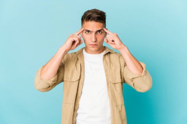 Kafkasyalı yakışıklı genç bir adam izole edilmiş bir vazifeye odaklanmış, parmaklarını işaret ediyor..