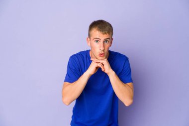 Kafkasyalı yakışıklı genç adam şans için dua ediyor, şaşırmış ve ağzını açıyor..