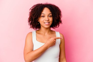 Genç Afro-Amerikan melez kadın kendini soyutlamış gülümsüyor ve boş uzayda bir şeyler gösteriyor..