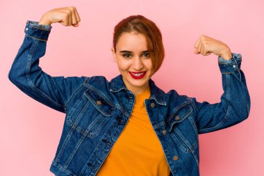 Genç Arap melez kadın güçlü hareketini kollarıyla gösteriyor, kadınsı gücün sembolü.