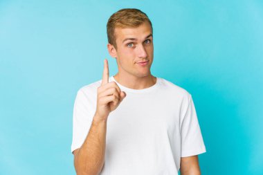 Genç, beyaz, yakışıklı bir numara parmağıyla görünüyor..