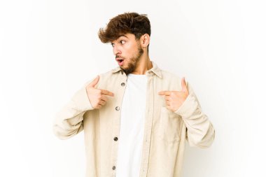 Beyaz arka planda genç bir Arap parmağını göstererek şaşırdı ve gülümsedi..