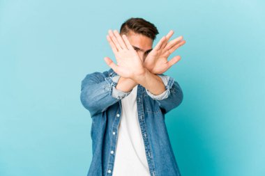 Genç, beyaz, yakışıklı bir adam izole edilmiş iki kolu çapraz tutuyor, inkar kavramı..