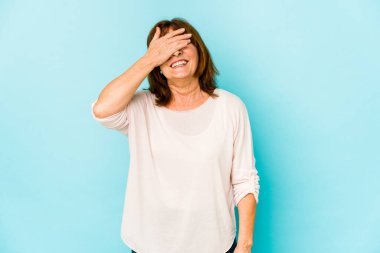 Üst düzey beyaz kadın, izole edilmiş, elleriyle gözlerini kapatıyor, gülümseyerek bir sürpriz bekliyor..