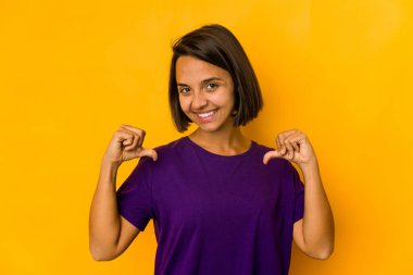 Sarıda izole edilmiş genç İspanyol kadın gururlu ve kendinden emin hissediyor, örnek olarak..