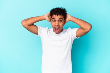 Genç Afro-Amerikalı kıvırcık adam mavi renkte izole edilmiş, çok heyecanlı, tutkulu, bir şeyden memnun..