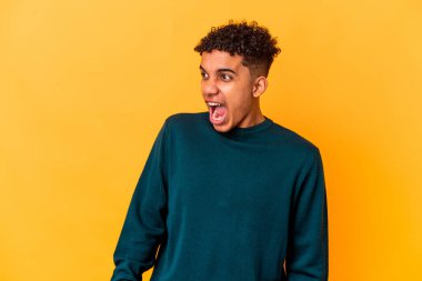 Genç Afro-Amerikalı kıvırcık adam, mor üzerine izole edilmiş, çok kızgın, öfkeli, hayal kırıklığına uğramış..