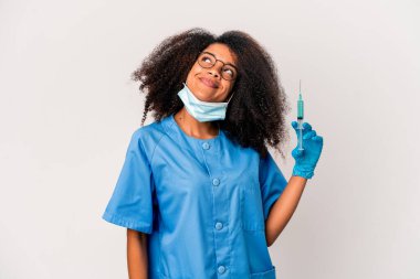 Genç Afro-Amerikan kıvırcık saçlı kadın elinde şırıngayla amaçlarına ve amaçlarına ulaşmayı hayal ediyor.