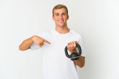 Beyaz arka planda izole edilmiş, tırnak yiyen, gergin ve endişeli bir halter tutan beyaz tenli genç adam..