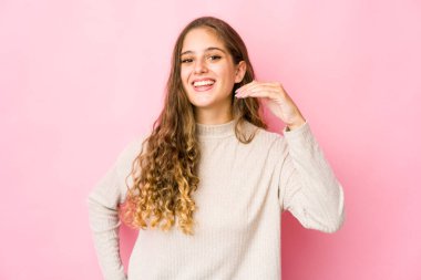 Kafkasyalı genç bir kadın bir şeye gülüyor, elleriyle ağzını kapatıyor..