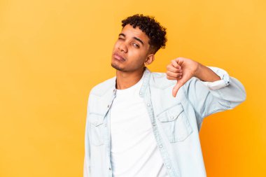 Genç Afro-Amerikalı kıvırcık adam, mor üzerine izole edilmiş, hoş olmayan bir jest yapıyor, başparmakları aşağıda. Anlaşmazlık konsepti.