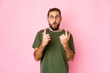 Uzun saçlı genç adam ağzı açık yukarı bakıyor..