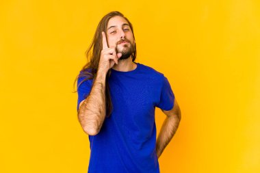 Uzun saçlı genç adam parmaklarıyla bir numarayı gösteriyor..