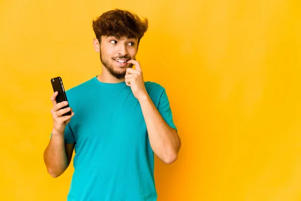 Ung Indian Man Som Håller Telefon Avslappnad Tänka Något Som — Stockfoto