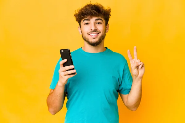 Jovem Indiano Segurando Telefone Mostrando Número Dois Com Dedos — Fotografia de Stock