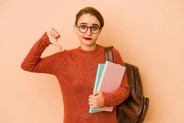 Young skinny arab student woman showing a dislike gesture, thumbs down. Disagreement concept.