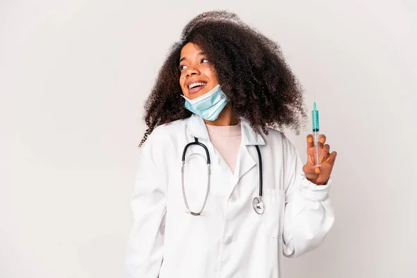 Młoda Afrykańska Kręcona Lekarka Trzymająca Strzykawkę Odwraca Wzrok Uśmiechnięta Wesoła — Zdjęcie stockowe