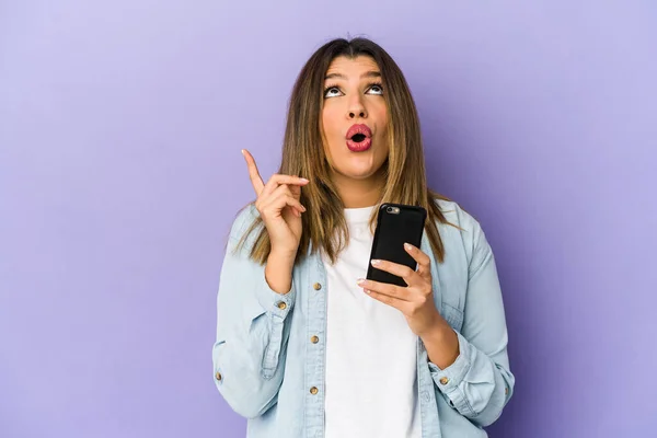 Jovem Indiana Segurando Telefone Isolado Apontando Cabeça Com Boca Aberta — Fotografia de Stock