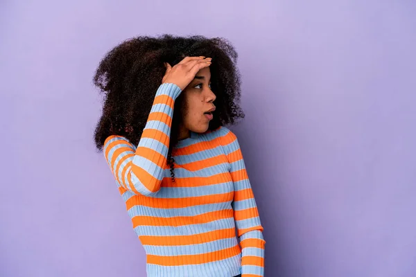 Mujer Rizada Afroamericana Joven Aislada Sobre Fondo Púrpura Mirando Lejos — Foto de Stock